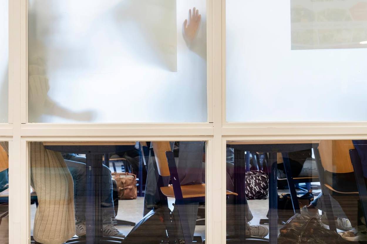 Kinderen in een klaslokaal met een geblindeerd raam